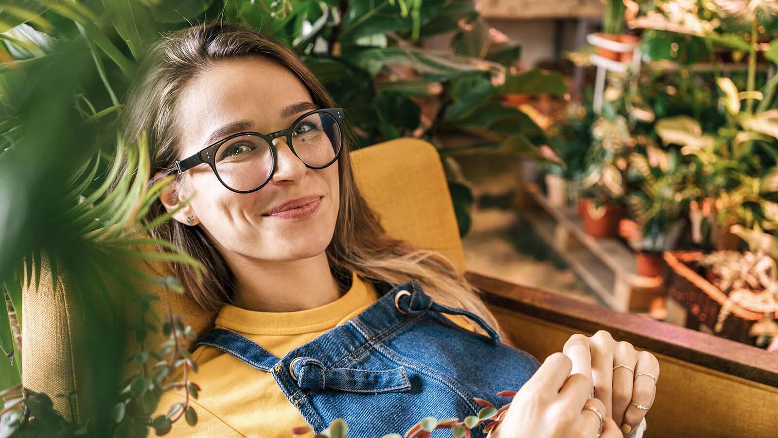 Mujer sonriente descansando entre plantas